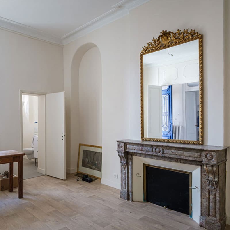 Intérieur bordelais rénové par Elkihel Peinture avec cheminée ancienne et murs aux finitions claires